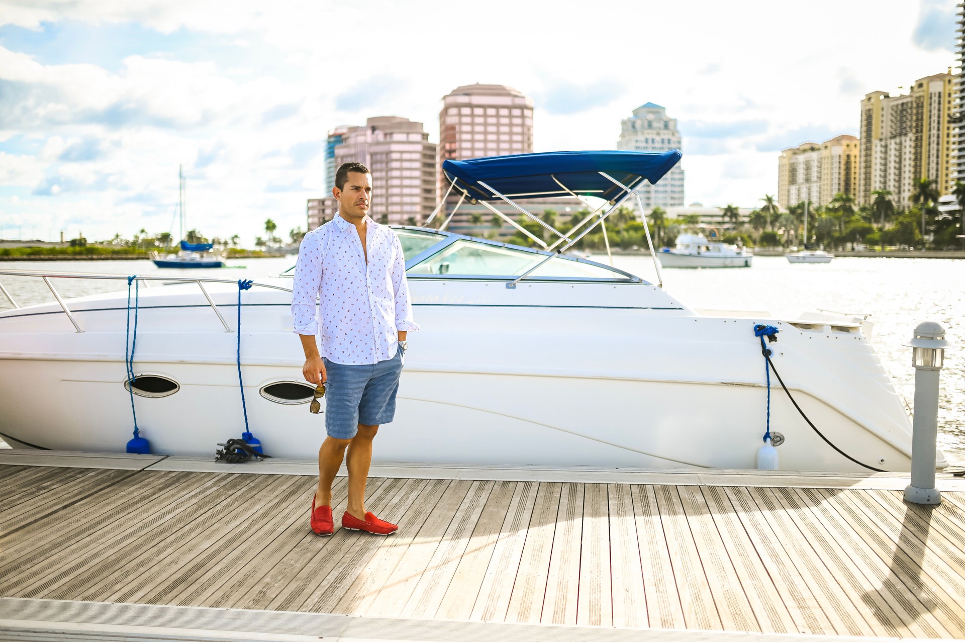 Handsome man on a boat dock with a speed boat, yachter